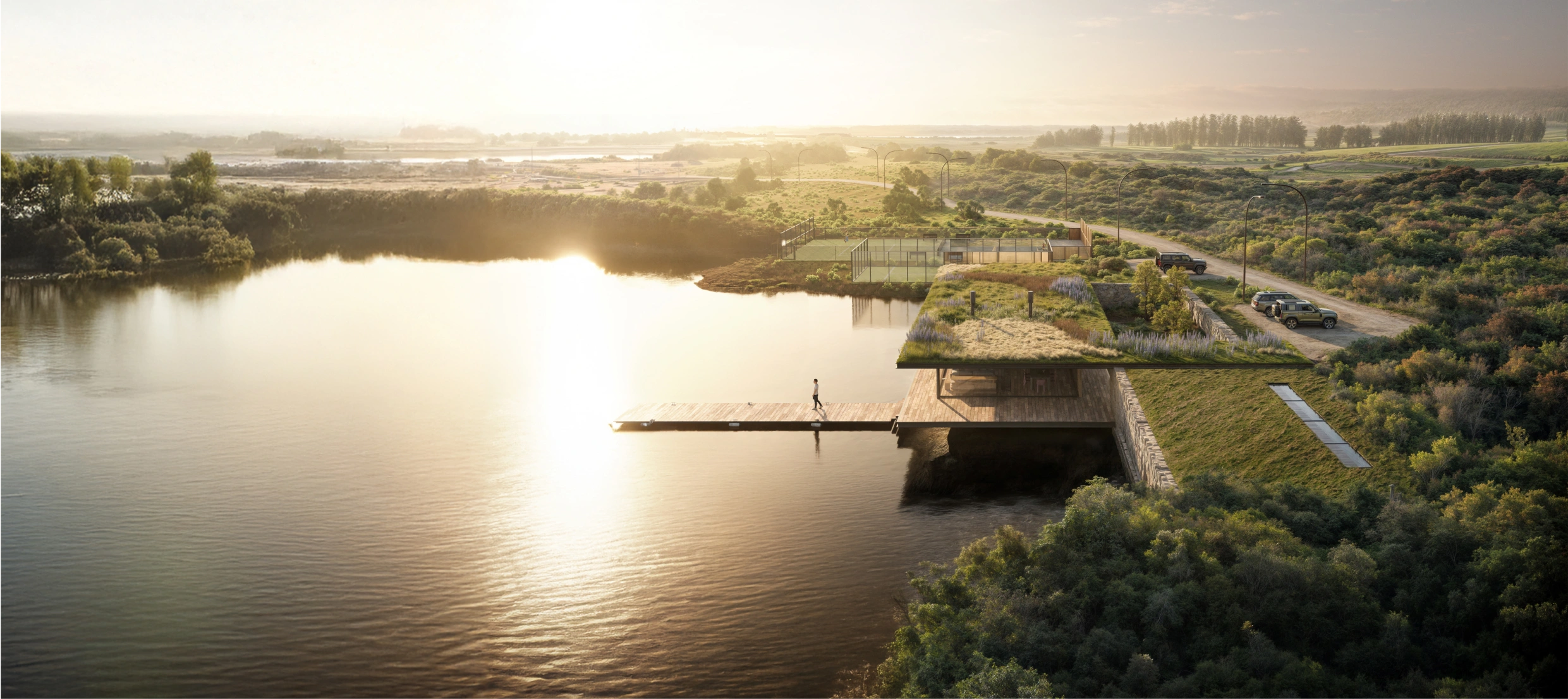 Imagen de una casa de campo moderna con un techo verde, ubicada junto a un lago y rodeada de naturaleza.