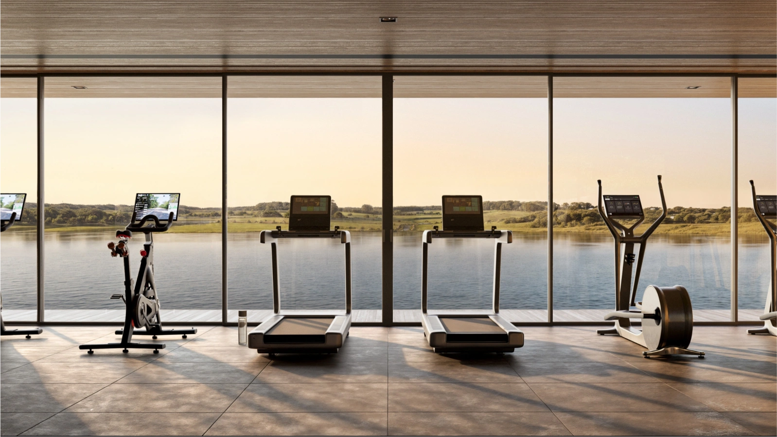 Moderno gimnasio con grandes ventanales que ofrecen vistas al lago. Equipamiento de última generación para ejercitarse mientras disfruta de la naturaleza.